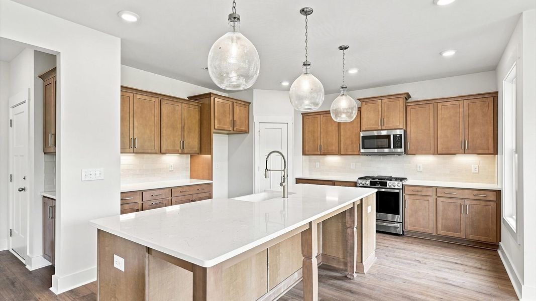 Exclusive DRB Homes kitchen with a 10-foot island, elevated finishes, and pendant lighting in a prime location