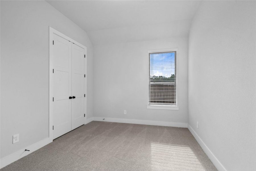 Perfect for guests or a quiet home office, this room features soft plush carpeting, a window with fitted blinds, sloped ceiling, and ample sized closet space. Perfect for guests or a quiet home office, this room features soft plush carpeting, a window with fitted blinds, sloped ceiling, and ample sized closet space.