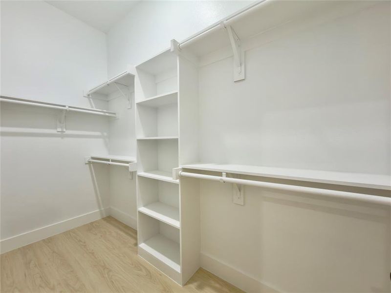 Spacious closet featuring light wood-style flooring