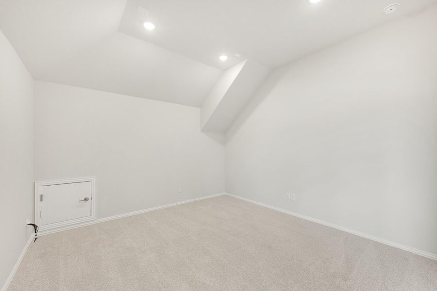 Empty bonus room with sloped ceiling, recessed lighting, carpet flooring, and small access panel on wall