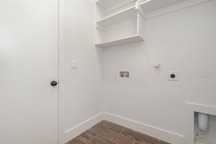 Laundry area with laundry area, hookup for a washing machine, electric dryer hookup, wood tiled floor, and baseboards