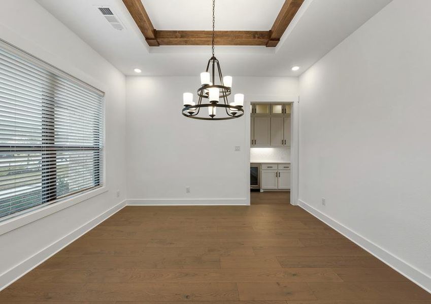 The formal dining room sits right off of the kitchen and has a large window.