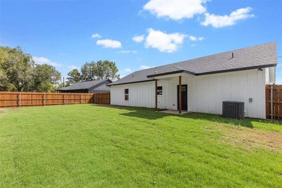 Back of house featuring a yard and central air condition unit