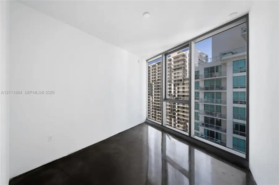 Floor-to-ceiling windows with dark metal framing and polished concrete flooring Floor-to-ceiling windows with dark metal framing and polished concrete flooring