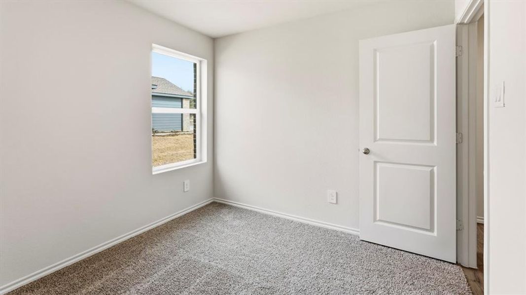 Spare room with light colored carpet and baseboards