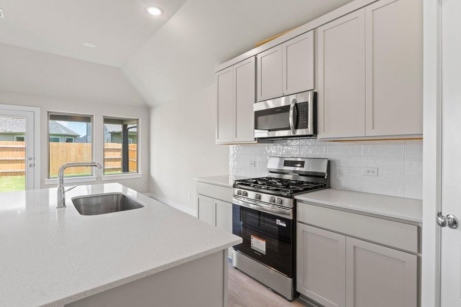 A well-appointed kitchen showcases stainless steel appliances and abundant counter space.