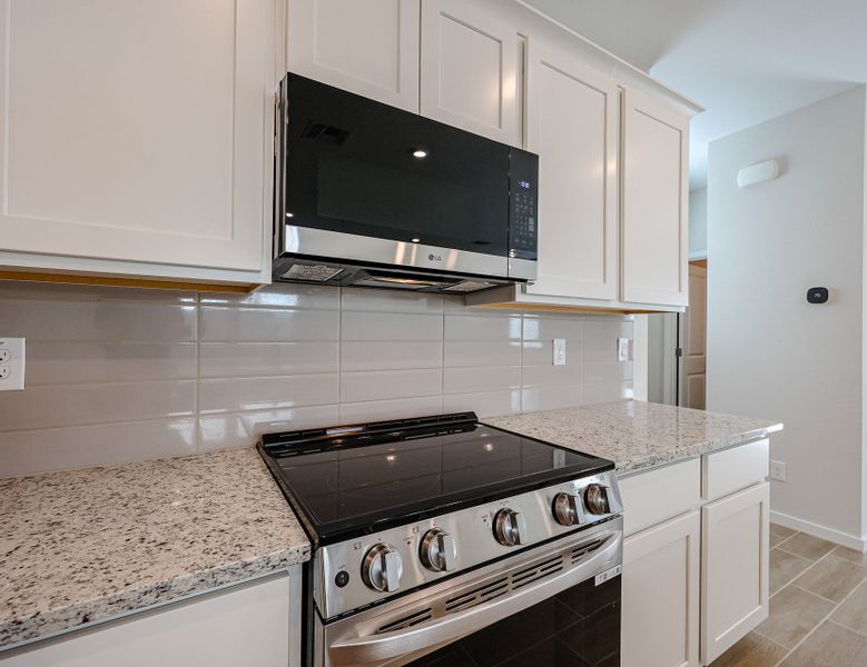 A kitchen with white cabinets.