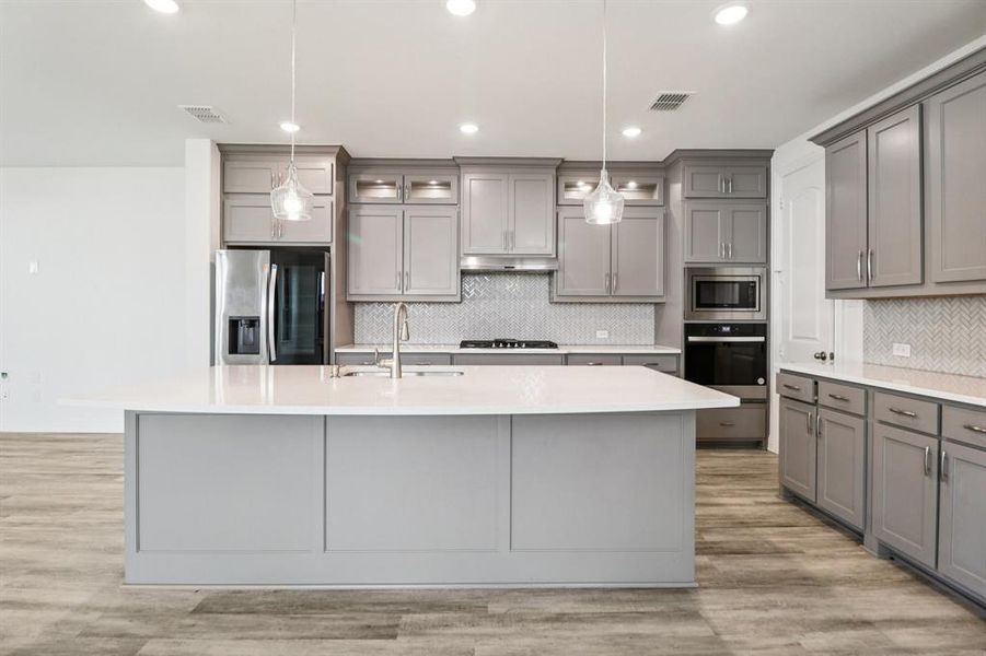 Kitchen featuring gray cabinetry, appliances with stainless steel finishes, recessed lighting, and light wood finished floors Kitchen featuring gray cabinetry, appliances with stainless steel finishes, recessed lighting, and light wood finished floors