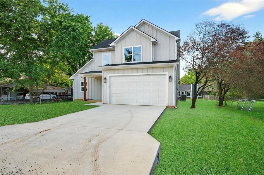 Modern farmhouse style home featuring board and batten siding, driveway, and a garage Modern farmhouse style home featuring board and batten siding, driveway, and a garage