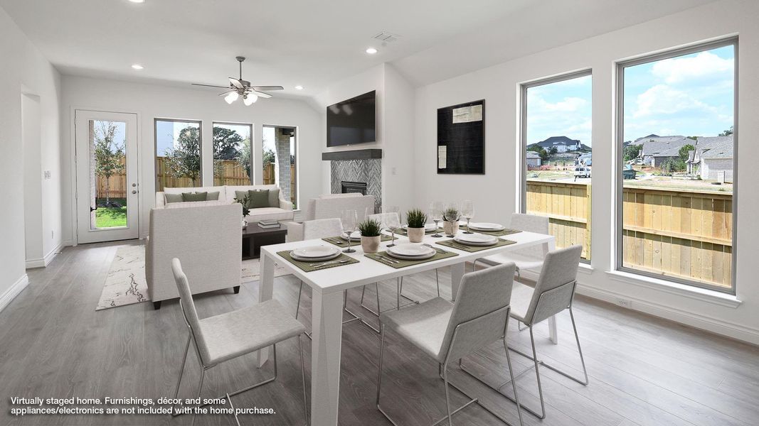 Dining area featuring a glass covered fireplace, wood finished floors, lofted ceiling, recessed lighting, and a ceiling fan Dining area featuring a glass covered fireplace, wood finished floors, lofted ceiling, recessed lighting, and a ceiling fan