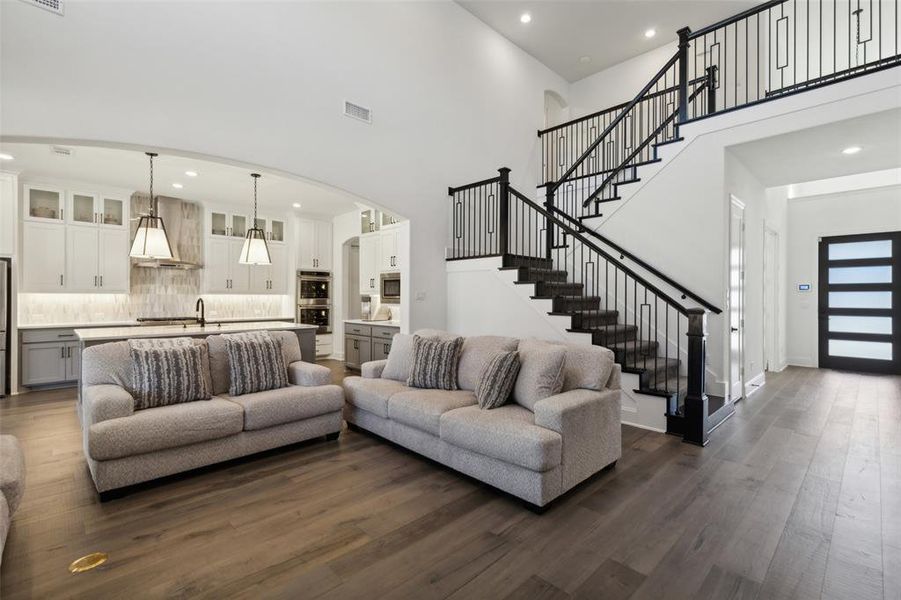 Living room with dark wood-type flooring and a high ceiling