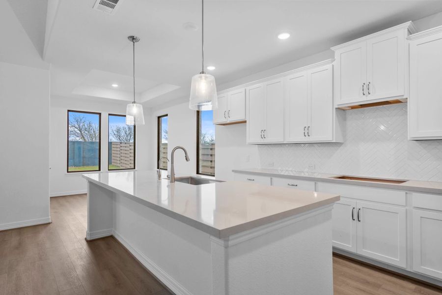 The oversized island with pendant lights is ready for relaxing breakfast and study sessions. The oversized island with pendant lights is ready for relaxing breakfast and study sessions.