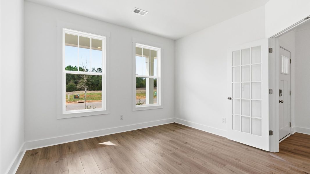 Vibrant natural light and tasteful design define this French door study near the front of the home located in Gray Court, SC