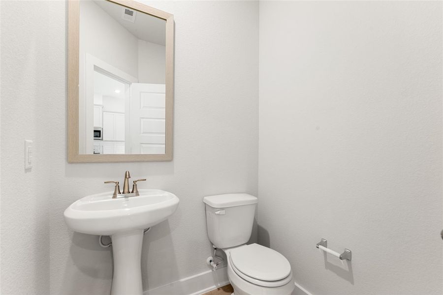 This half bath features a clean, minimalist design with neutral tones and a pedestal sink. Bright and polished, it offers a simple yet elegant touch for guests and everyday use. This half bath features a clean, minimalist design with neutral tones and a pedestal sink. Bright and polished, it offers a simple yet elegant touch for guests and everyday use.