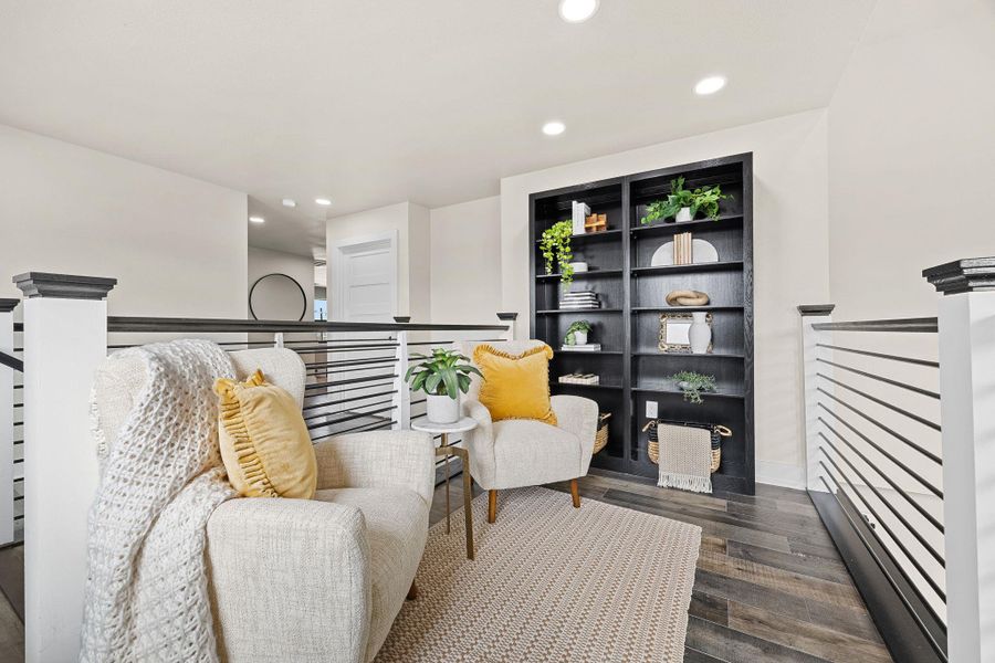 Living area featuring an upstairs landing, recessed lighting, and dark wood-type flooring Living area featuring an upstairs landing, recessed lighting, and dark wood-type flooring