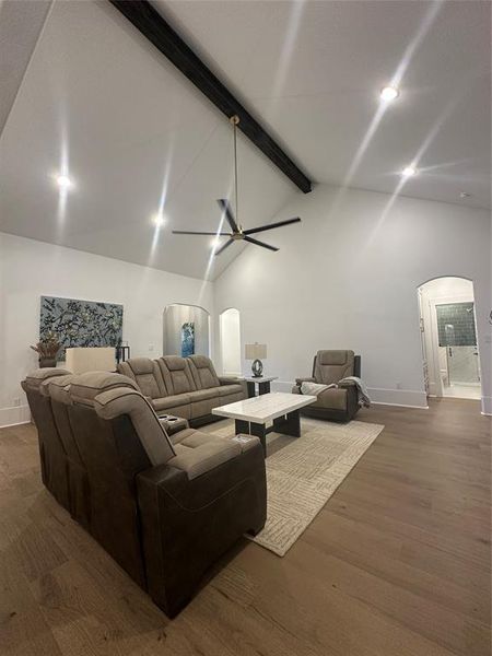 Vaulted white ceilings featuring a dark wood beam and recessed lighting