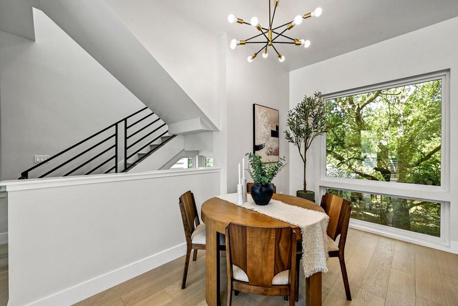 Dining space with stylish light fixture. (This is Unit #2 - each Unit has the same layout, however a few differing details such as light fixtures, custom cabinet/backsplash/tile colors)