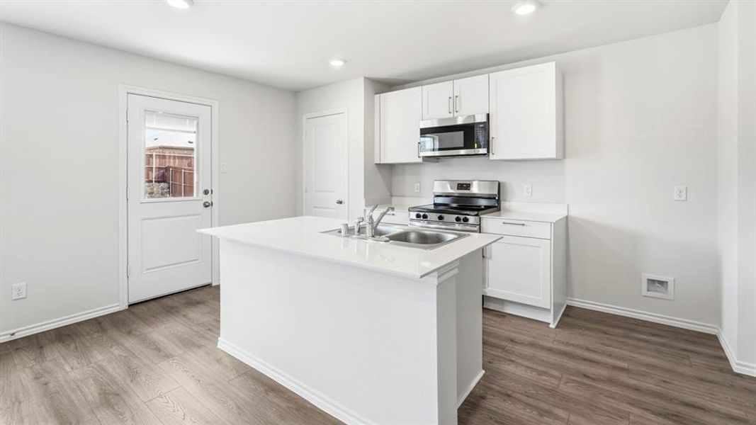 Kitchen with stainless steel appliances, white cabinetry, a kitchen island with sink, dark wood finished floors, and recessed lighting