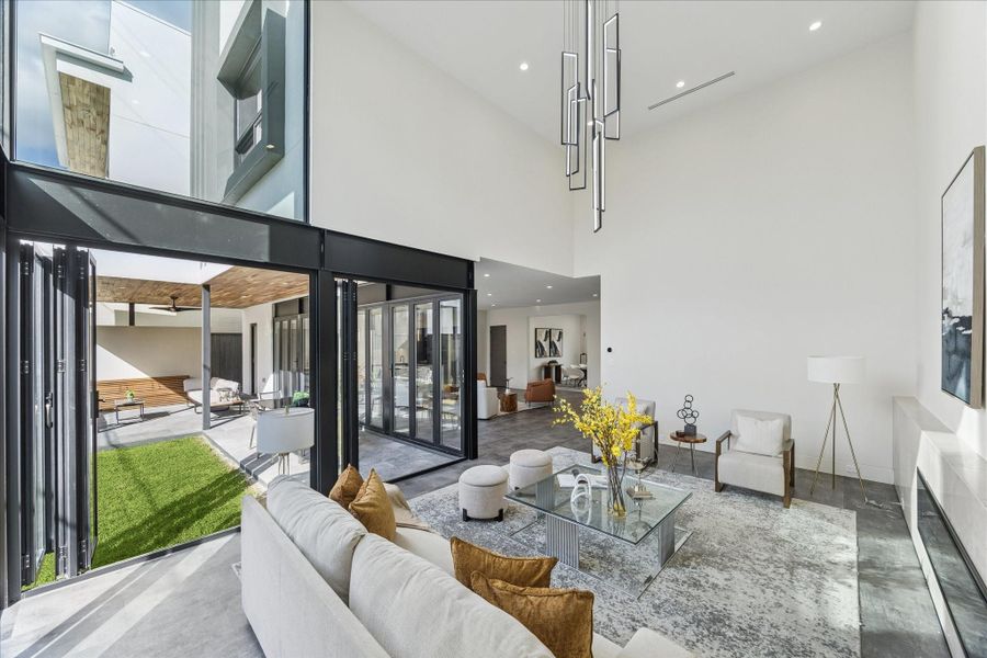 Explore the impressive formal living area with soaring 21-foot ceilings, a cozy gas fireplace, and seamless access to the patio through sliding doors.