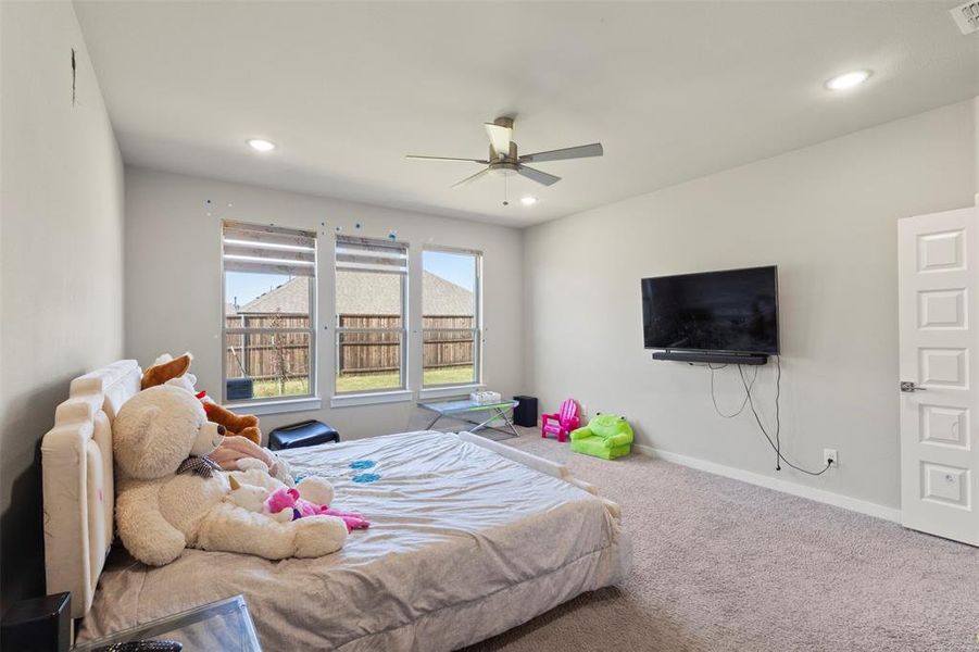 Carpeted bedroom featuring ceiling fan and recessed lighting