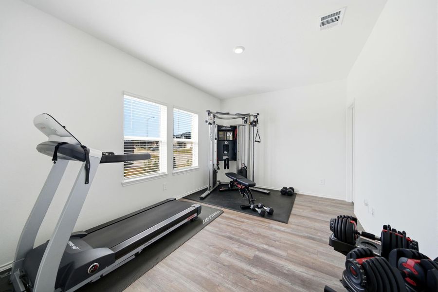 Light-filled study/flex space near the entrance with seamless vinyl plank flooring and a walk-in closet—ideal for work, an at-home gym, or hobbies.