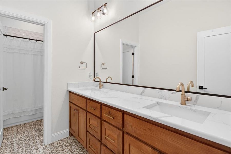 Full bathroom featuring double vanity and shower / bath combo with shower curtain Full bathroom featuring double vanity and shower / bath combo with shower curtain
