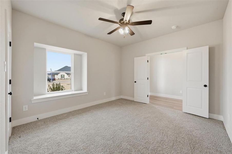 Unfurnished bedroom featuring light colored carpet and a ceiling fan