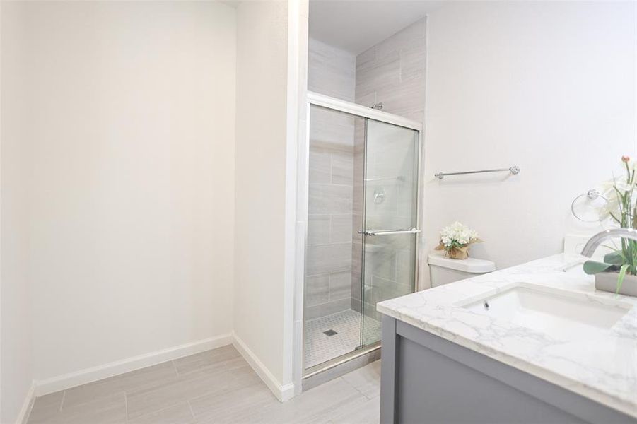 Bathroom with a stall shower and vanity