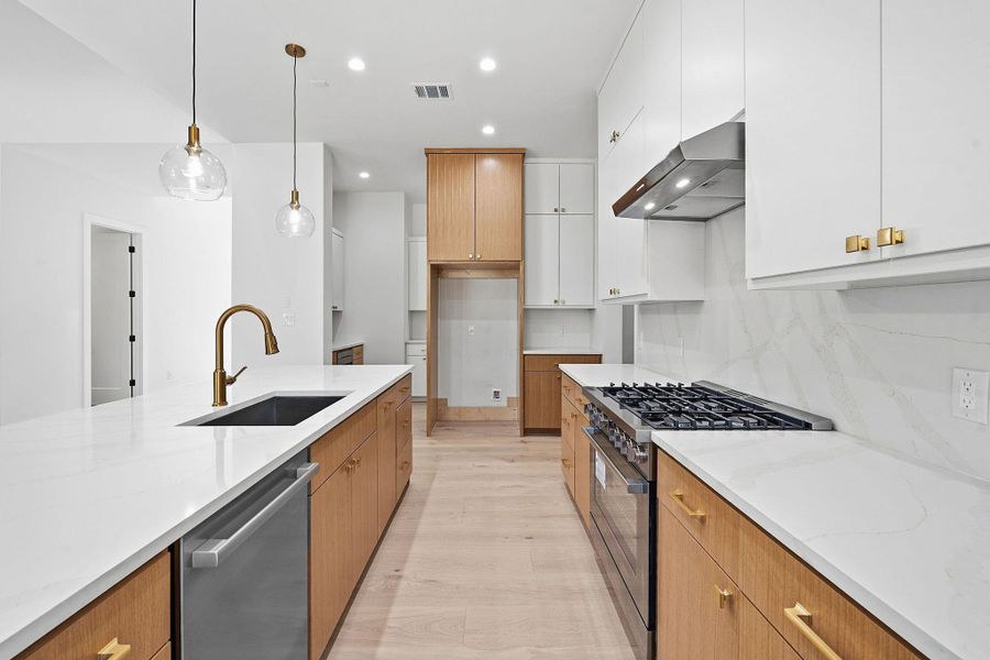 Gleaming stone countertops and modern cabinetry line this streamlined kitchen space.