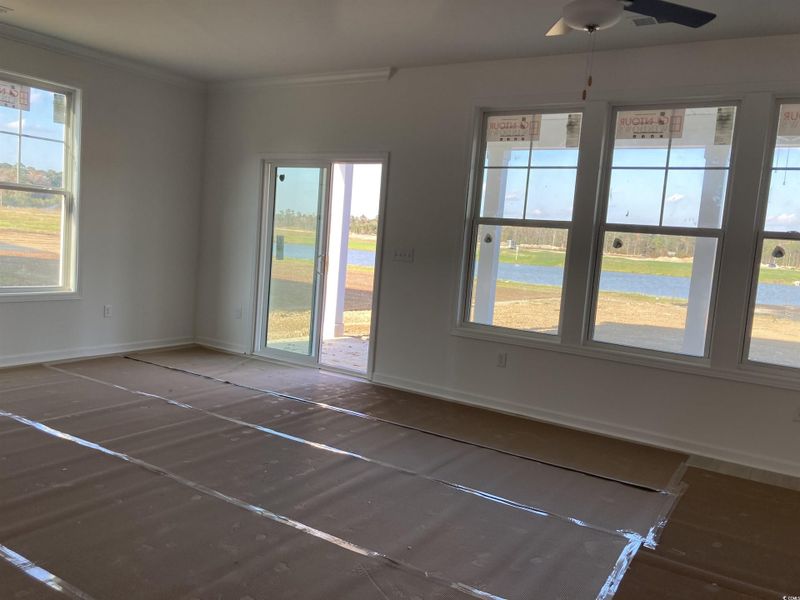 Spare room featuring a water view, a ceiling fan, and ornamental molding