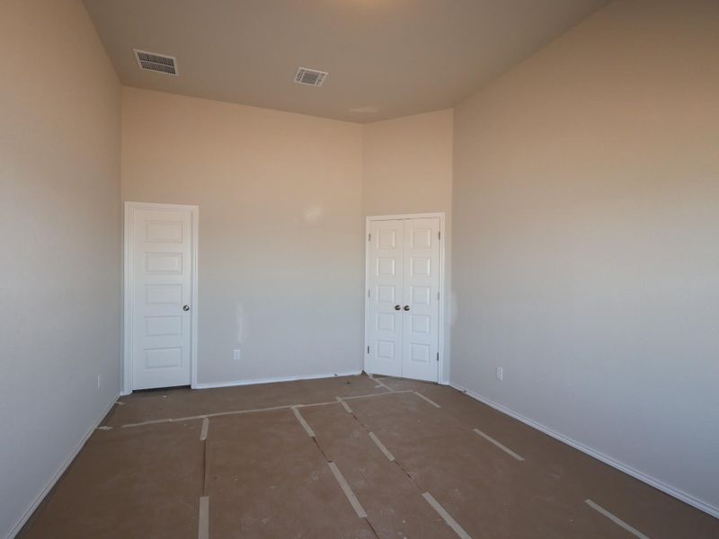 Spare room with a high ceiling and baseboards