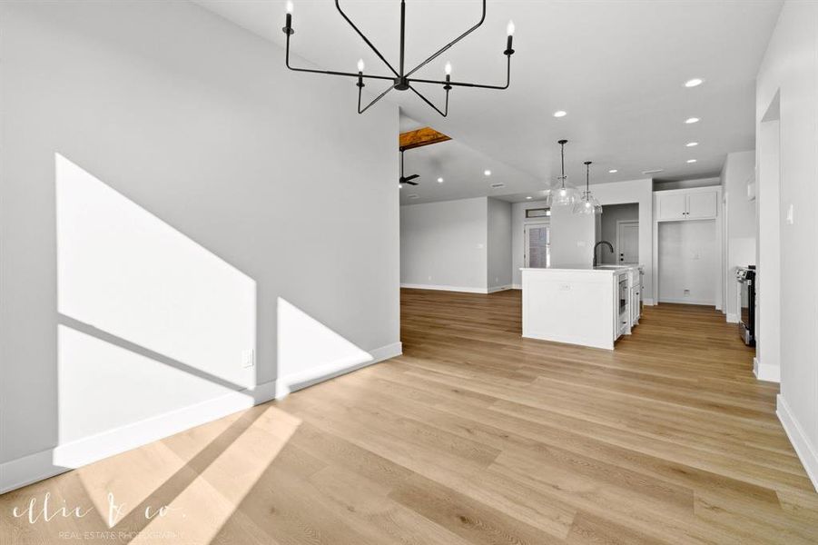 Kitchen with a center island with sink, recessed lighting, open floor plan, a chandelier, and pendant lighting