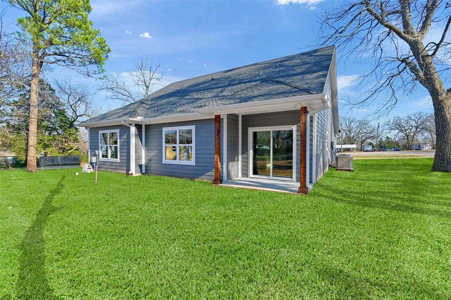 Back of house with a yard and central AC unit