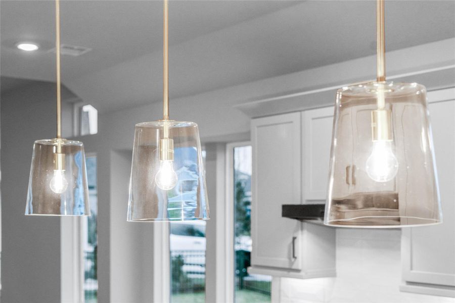 The Clarion pendant light fixtures located over the kitchen countertop gives added light into the kitchen - adding a sleek, reflective accent.