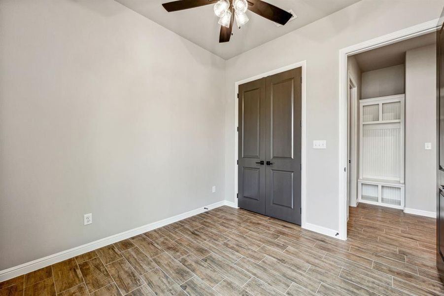 Unfurnished bedroom with ceiling fan and light hardwood / wood-style flooring