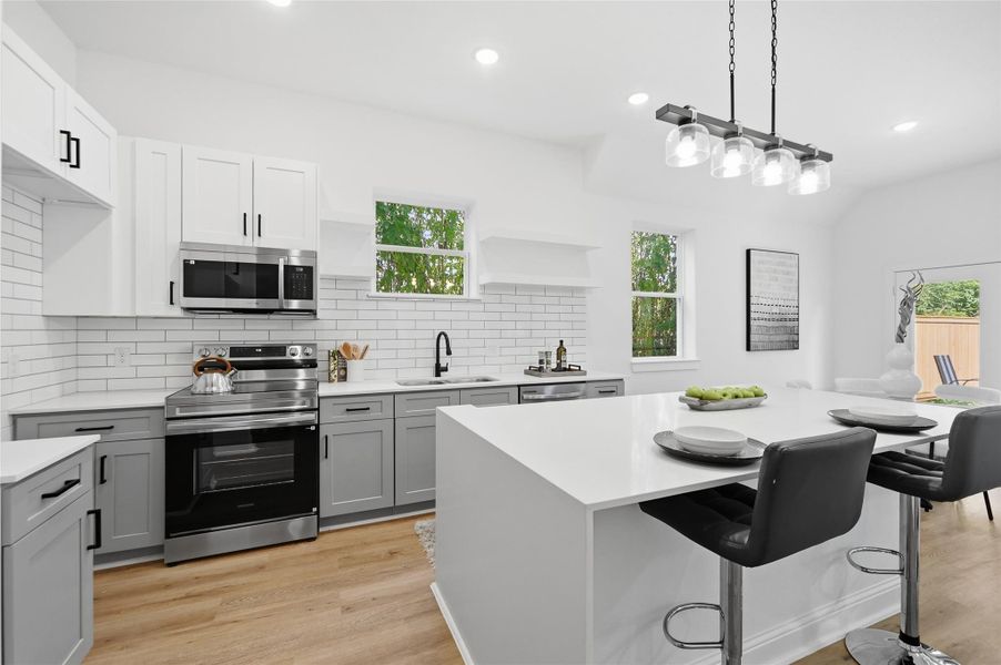 Open concept kitchen, dining and living room, with lots of natural light.