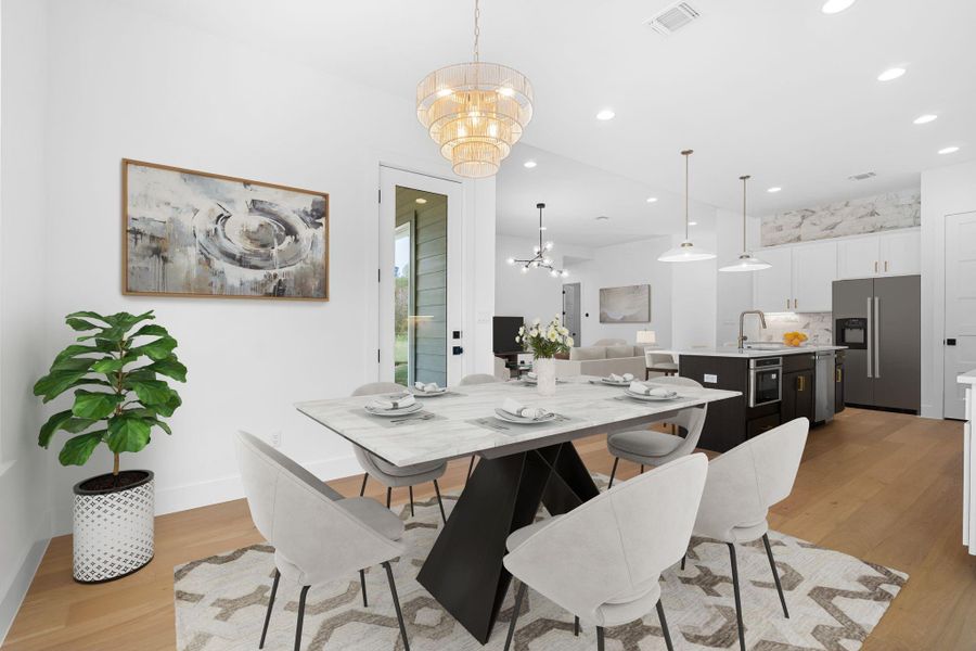 Dining space featuring sink, a chandelier, and light hardwood / wood-style flooring Dining space featuring sink, a chandelier, and light hardwood / wood-style flooring