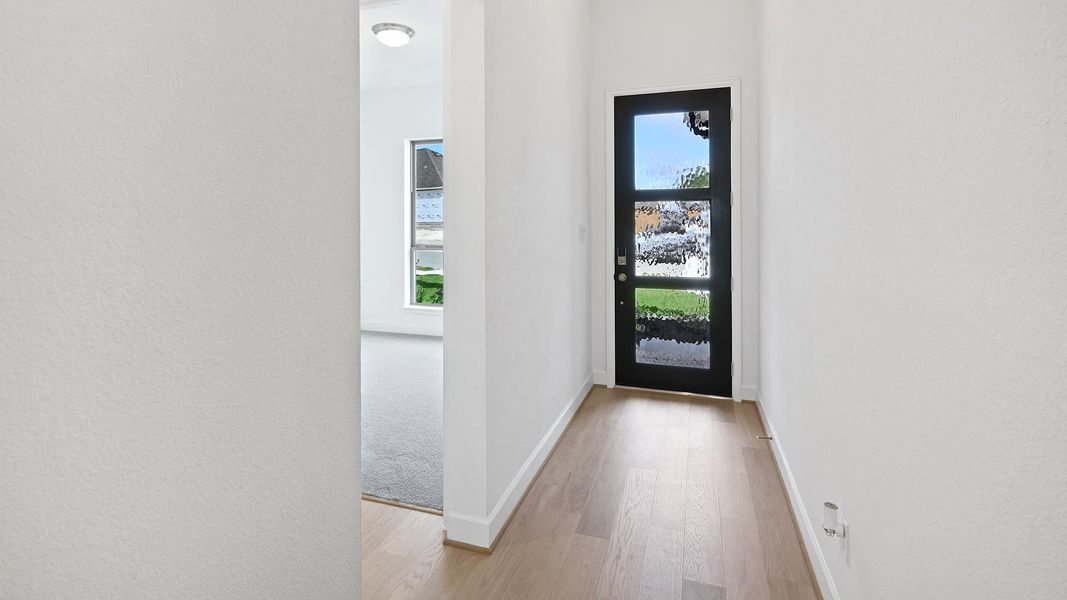 Foyer entrance featuring light wood finished floors and a textured wall