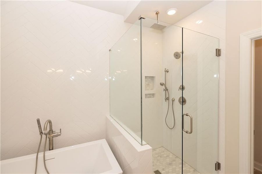 Bathroom featuring a soaking tub, a stall shower, and recessed lighting