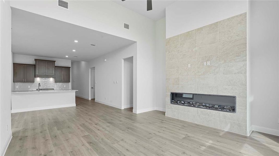 Vaulted ceilings highlight a tiled fireplace feature wall with a linear electric fireplace insert