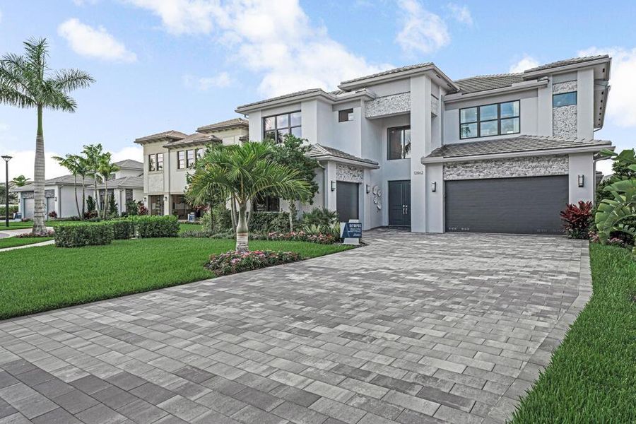 Front exterior of a new home in Apex at Avenir, Palm Beach Gardens, FL, highlighting curb appeal (Image 24).