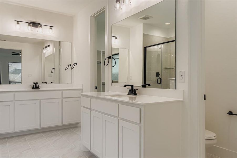 Full bath with a stall shower, light tile patterned floors, two vanities, and ceiling fan Full bath with a stall shower, light tile patterned floors, two vanities, and ceiling fan