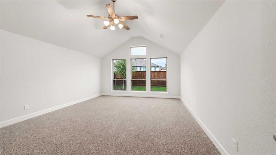 Additional living space featuring vaulted ceiling, light colored carpet, and ceiling fan