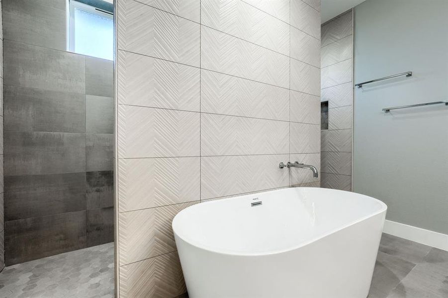 Bathroom featuring tile walls and shower with separate bathtub