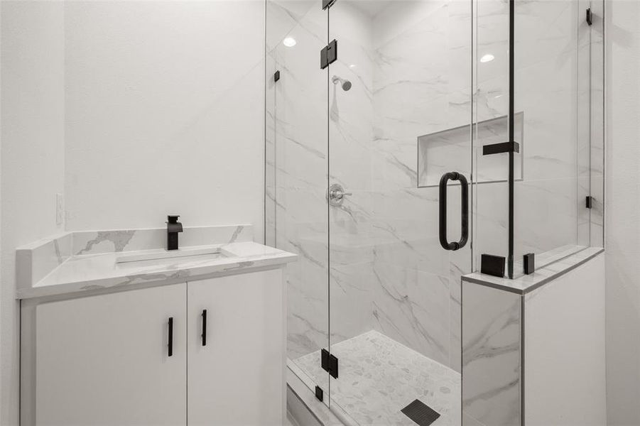Full bath with a marble finish shower and vanity Full bath with a marble finish shower and vanity