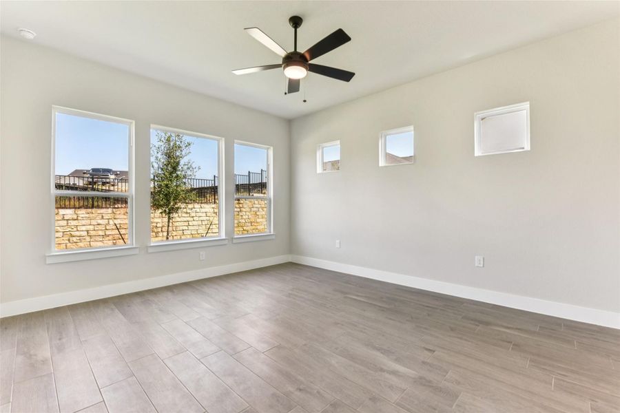Spare room featuring light wood-type flooring, plenty of natural light, and ceiling fan Spare room featuring light wood-type flooring, plenty of natural light, and ceiling fan