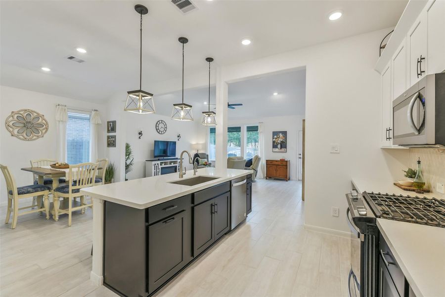 The stylish pendant lights add charm over the spacious island. With beautifully contrasting dark lower and white upper cabinets, this kitchen is truly the heart of the home!