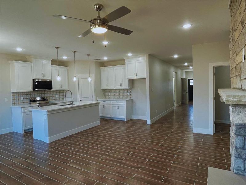 Kitchen featuring white cabinetry, sink, a kitchen island with sink, and stainless steel appliances