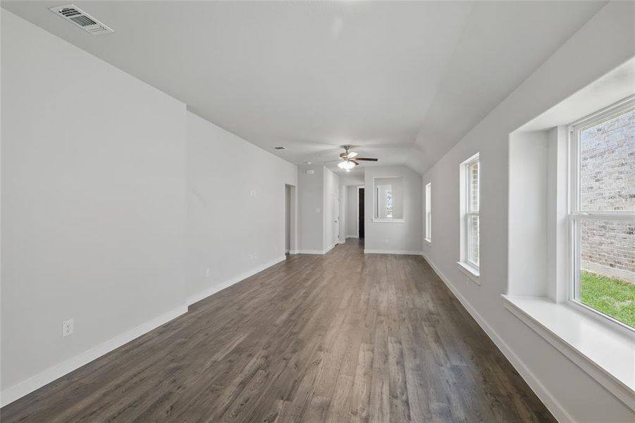 Unfurnished living room with dark wood-type flooring and a ceiling fan Unfurnished living room with dark wood-type flooring and a ceiling fan