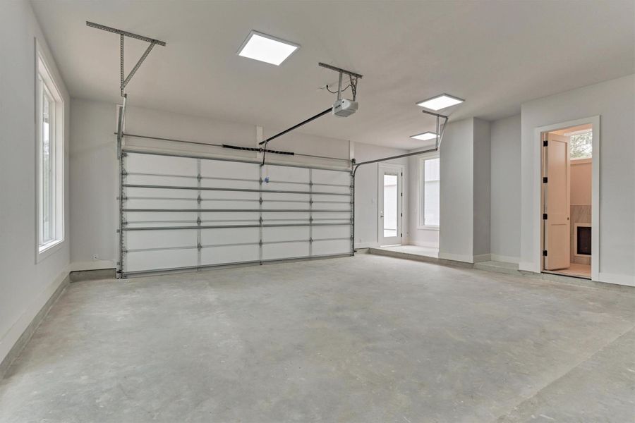 Oversized attached garage with bright LED lighting, dual doors, and direct access to the home—ideal for vehicles, storage, and everyday convenience.